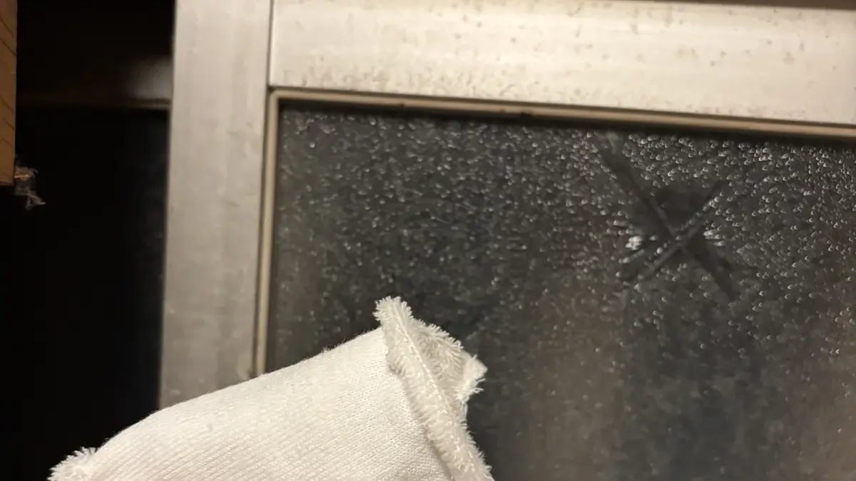 白サビを乾いた布でこすっても落ちないことを確かめている様子